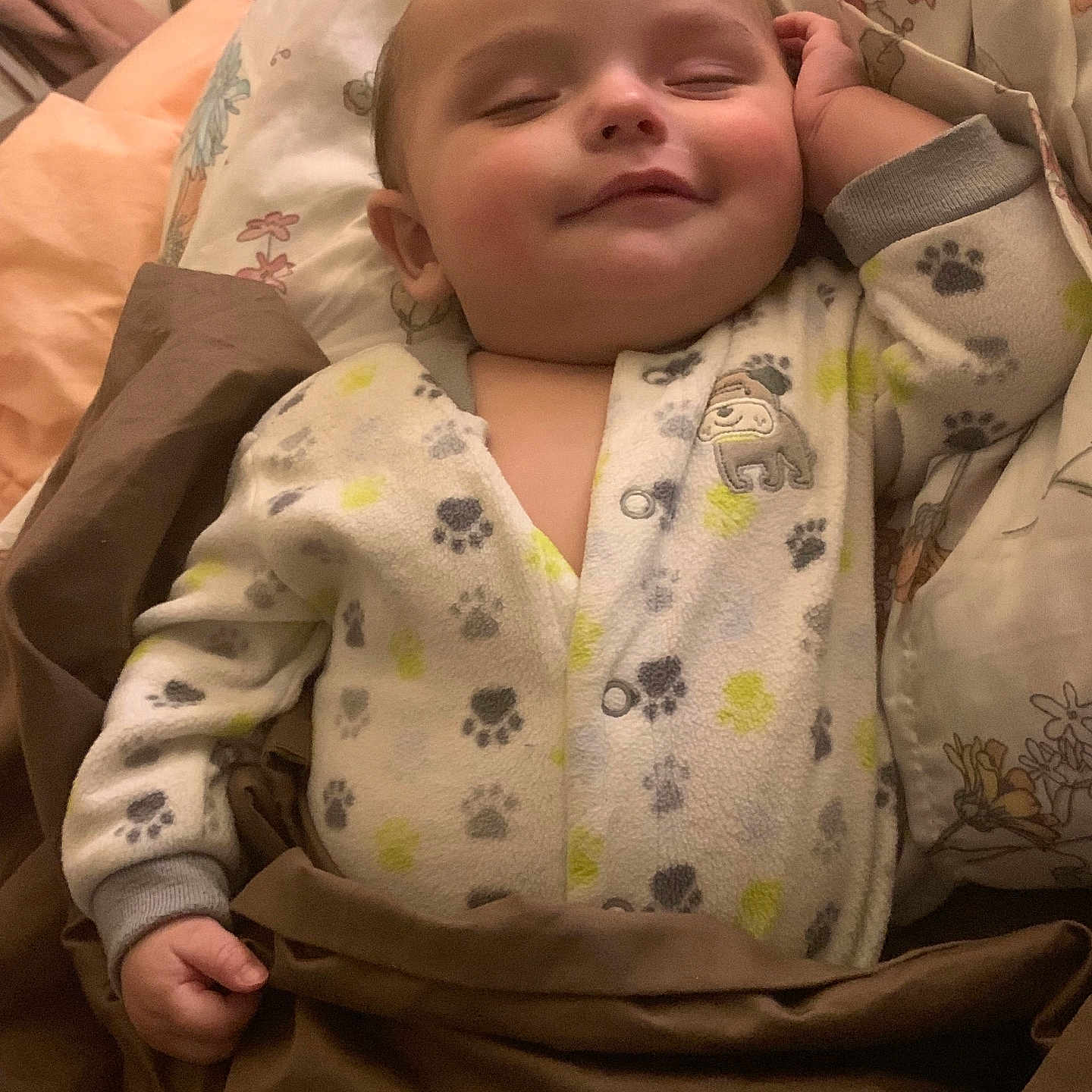 Angelito is registered to the contest to win money with this photo: baby, sleeping, onesie, paw_print, blanket, cozy, infant, hand, closed_eyes, smile, bedroom, pillow, soft_lighting, cute, child, indoor, peaceful, cute_outfit, sleep, toddler