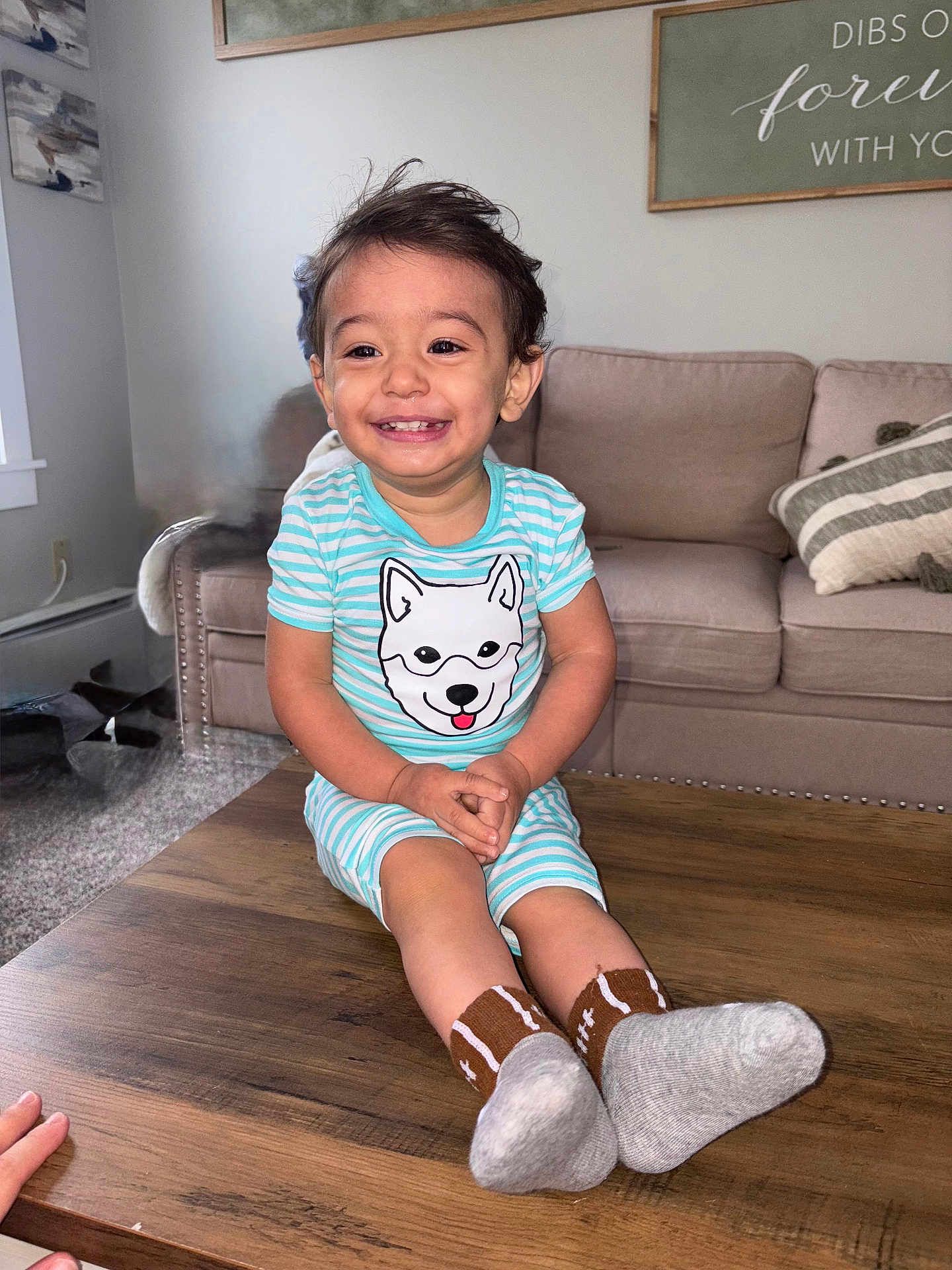 Azariell joined the competition — help win amazing prizes! carpet, child, couch, cute, dog_print, furniture, hands, happy, indoor, living_room, person, pillow, sitting, smiling, socks, striped_clothing, table, toddler, wall_art, wood