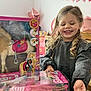 child, girl, smiling, toy, barbie, horse, packaging, gift, present, balloon, curly_hair, indoor, wooden_chair, celebration, happy, person, play, doll, pink, holiday