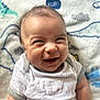 Archer joined the competition — help win amazing prizes! baby, smiling, infant, onesie, blanket, dinosaur_pattern, happy, face, cute, child, lying_down, soft_texture, young, cheerful, indoor, portrait, small_person, clothing, funny_expression, head