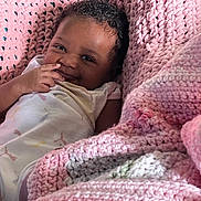 Nola Cummings joined the competition — help win amazing prizes! baby, blanket, child, clothing, comfort, cozy, crochet, curly_hair, cute, expression, face, hand, happy, infant, lying_down, pink, portrait, skin, smile, warm