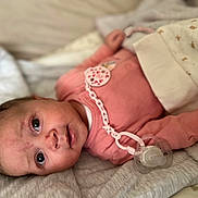 Assil a rejoint le concours — aidez-le/la à gagner de superbes lots ! baby, infant, newborn, pacifier, pacifier_clip, pacifier_chain, onesie, pink_clothing, blanket, bedding, lying_down, portrait, close_up, big_eyes, gaze, adorable, cozy, soft_texture, sleeping_area, skin