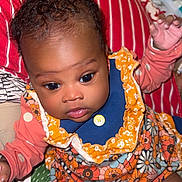 Kehlani joined the competition — help win amazing prizes! baby, infant, child, face, eyes, clothing, floral_pattern, orange, blue, socks, blanket, pillow, indoor, cute, portrait, skin, hands, sitting, person, young