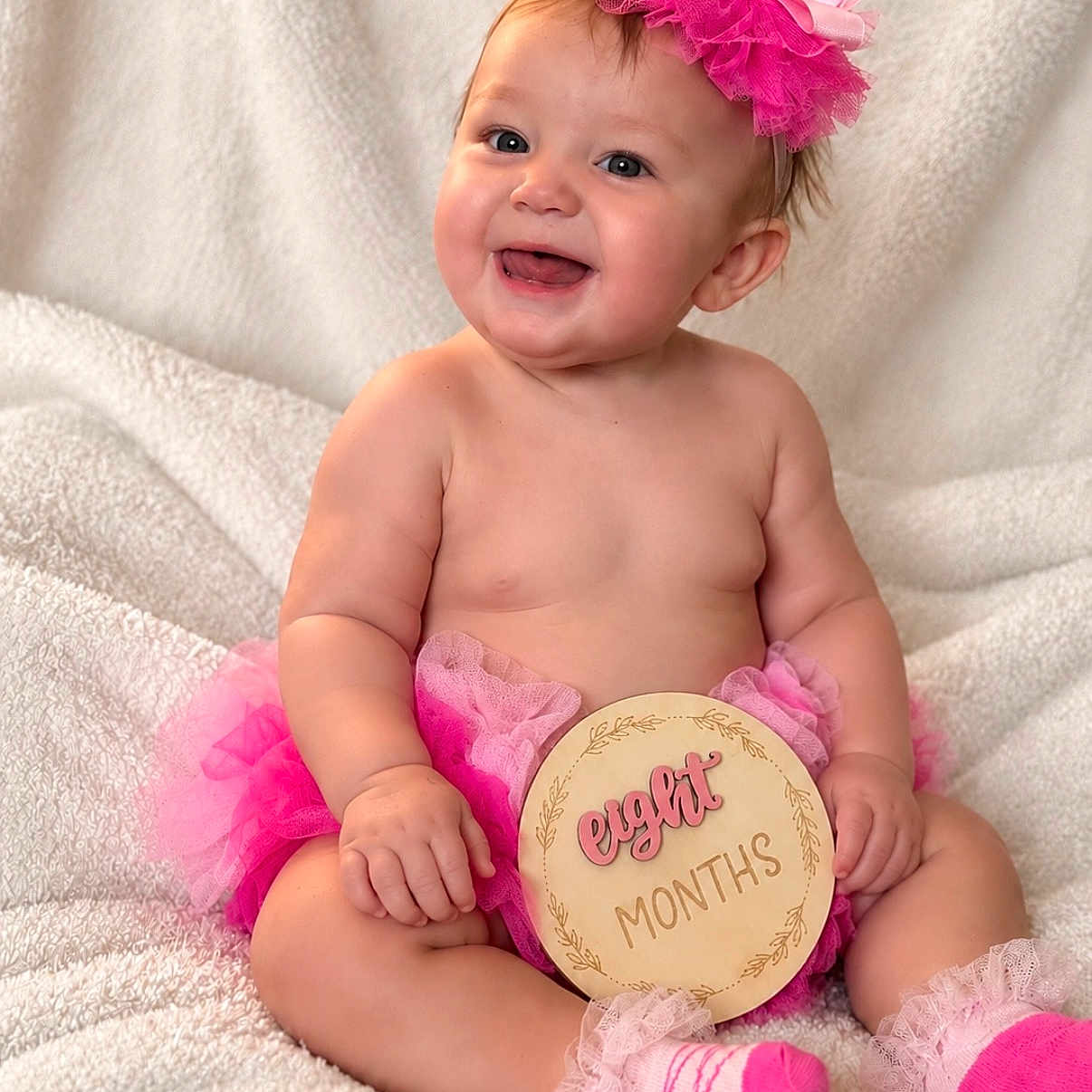 Hayley joined the competition — help win amazing prizes! baby, infant, child, portrait, smiling, happy, sitting, pink, hair_bow, tutu, frilly_socks, milestone, eight_months, plaque, blanket, indoor, studio_portrait, cute, celebration, photography