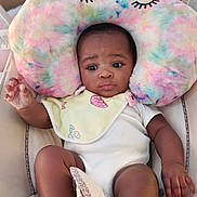 Cherish is registered to the contest to win money with this photo: baby, infant, child, plush_pillow, colorful, bib, heart_pattern, seat, cushion, clothing, relaxed, indoor, skin, hand, foot, portrait, expression, comfortable, soft_toy, curious