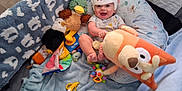 Colton is registered to the contest to win money with this photo: baby, baby_boy, blanket, child, clothing, colorful, cute, floor, happy, helmet, indoor, infant, pillow, playpen, plush_toy, smiling, soft, stuffed_duck, stuffed_eagle, toy