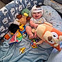 baby, baby_boy, blanket, child, clothing, colorful, cute, floor, happy, helmet, indoor, infant, pillow, playpen, plush_toy, smiling, soft, stuffed_duck, stuffed_eagle, toy