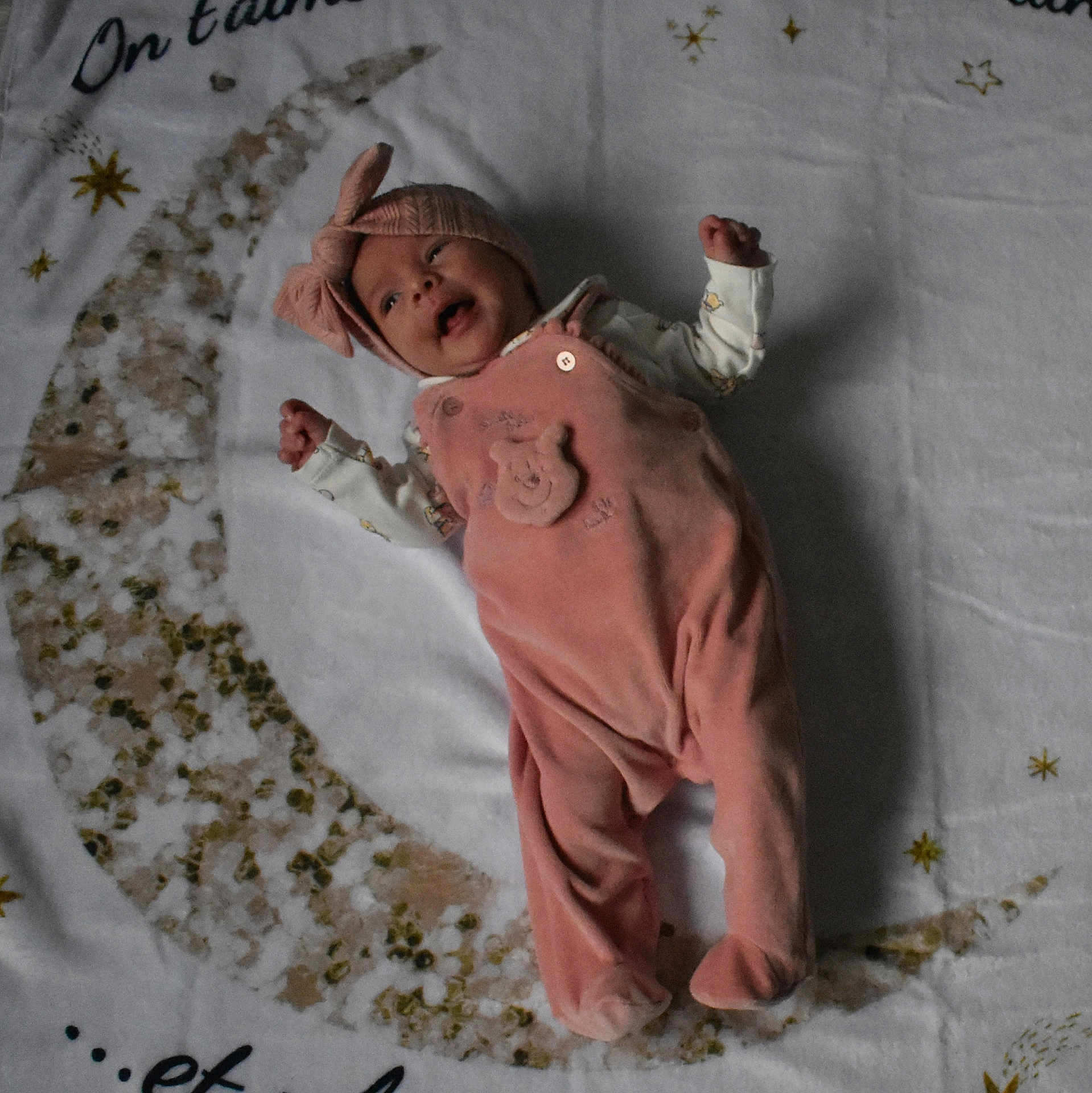 Malia participe au concours pour gagner de l'argent avec cette photo : baby, infant, pink_outfit, headband, blanket, crescent_moon, stars, lying_down, happy, smiling, soft_toy_design, cozy, child, cute, indoors, sleepwear, fabric, decor, portrait, newborn