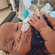 Jackson joined the competition — help win amazing prizes! newborn, baby, hospital, medical_tube, nasal_cannula, infant, closeup, healthcare, patient, child, medical_tape, soft_toy, bed, clothing, person, skin, hand, face, resting, indoors