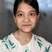 Andra Maria participe au concours pour gagner de l'argent avec cette photo : child, girl, portrait, face, smile, eyes, hair, white_shirt, green_leaves, pattern, young, person, indoors, casual_clothing, cute, headshot, childhood, happy, pretty, fashion