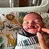 Ruger is registered to the contest to win money with this photo: newborn, baby, hospital, blanket, animal_print, smile, face, infant, swaddled, person, cute, child, healthcare, bed, hand, skin, closeup, peaceful, resting, indoors
