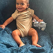Ben participe au concours pour gagner de l'argent avec cette photo : baby, child, smiling, plush_toy, blanket, blue, happy, cute, infant, clothing, sitting, face, hand, foot, indoors, portrait, soft_texture, comfort, toy, young