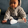 Ben participe au concours pour gagner de l'argent avec cette photo : toddler, child, hoodie, plush_clothing, couch, blue_couch, footwear, white_shoes, baby, cute, indoor, seated, looking_away, curious, small_hands, soft_texture, casual_wear, portrait, cozy, young_child