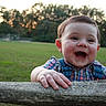baby, child, smiling, happy, outdoor, park, grass, trees, sunset, portrait, face, eyes, mouth, hands, wood, log, plaid_shirt, overalls, baby_boy, nature