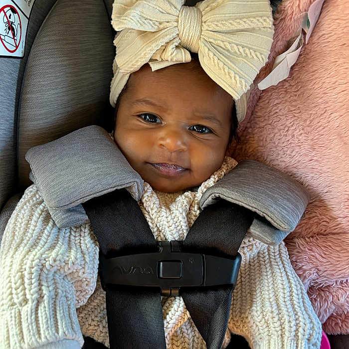 Tiffany joined the competition — help win amazing prizes! baby, bonnet, cap, car, car_interior, carseat, clothing, coat, couch, face, furniture, hat, head, knitwear, person, photography, portrait, sweater, transportation, vehicle
