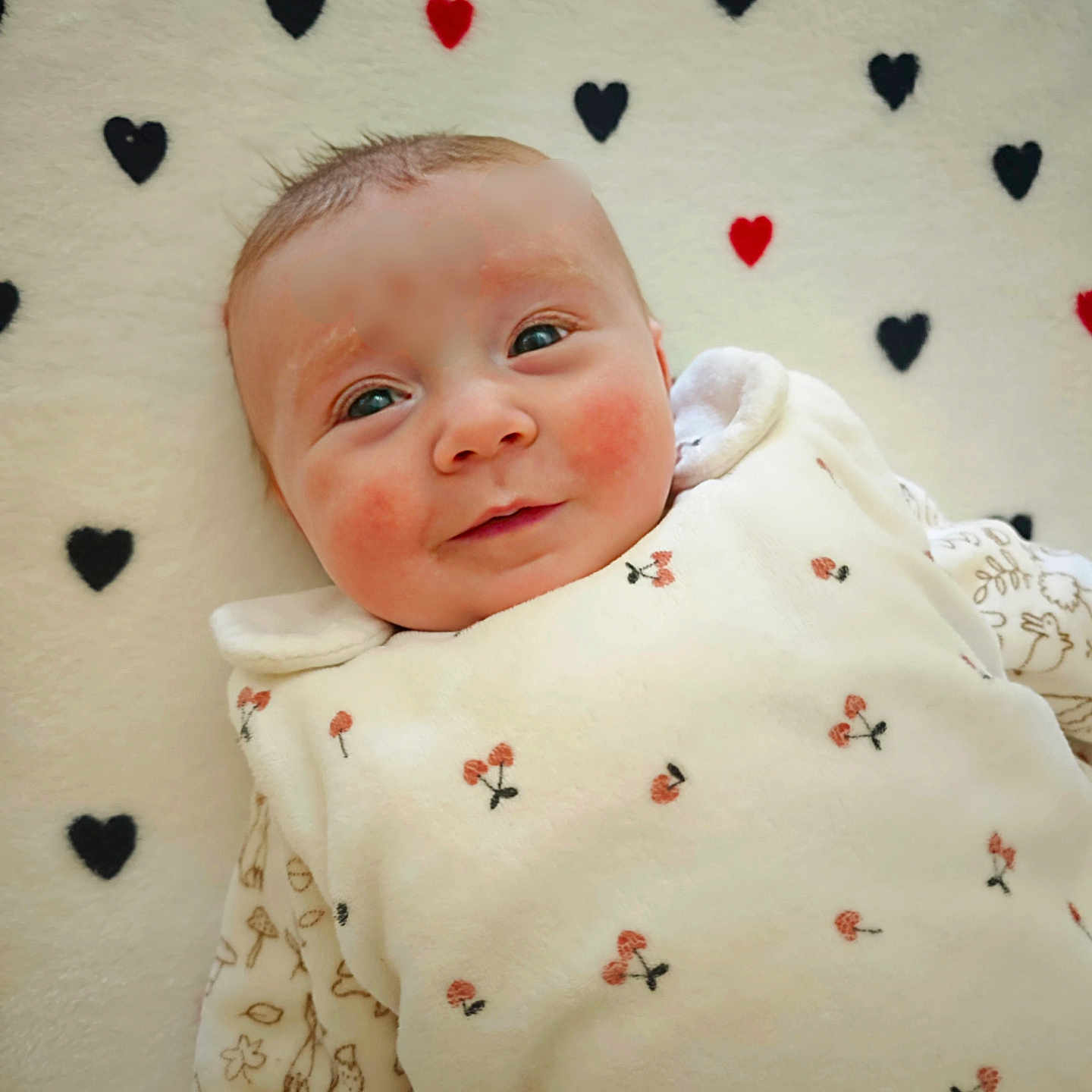 Effy a rejoint le concours — aidez-le/la à gagner de superbes lots ! baby, blanket, cherry_pattern, child, cozy, cute, face, happy, heart_pattern, indoors, infant, lying_down, newborn, person, portrait, rosy_cheeks, smile, soft_texture, warm, white_clothing