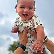Jaxx is registered to the contest to win money with this photo: animal_print, baby, bracelet, child, clouds, cute, hands, happy, holding, infant, joy, nature, outdoor, person, playful, portrait, short_sleeves, sky, smiling, wristwatch