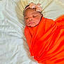 Olakamiye is registered to the contest to win money with this photo: newborn, baby, sleeping, swaddle, orange_cloth, headband, pink_bow, blanket, soft_texture, peaceful, infant, cute, portrait, closeup, indoors, resting, wrapped, child, adorable, face