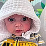 baby, child, hood, white, striped_clothing, yellow, construction_truck, face, eyes, cute, infant, portrait, expression, indoor, colorful_background, cartoon_animals, curious, closeup, clothing, soft_texture