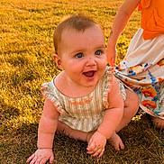 Bailey Baize joined the competition — help win amazing prizes! baby, child, infant, smiling, happy, sitting, outdoors, grass, field, portrait, sunlight, sunset, dress, floral_skirt, adult, parent, park, landscape, summer, family
