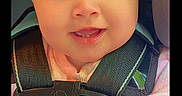 Bailey Baize is registered to the contest to win money with this photo: baby, black_background, car_seat, child, close_up, eyes, face, happy, indoor, infant, morning, photograph, pink_clothing, portrait, safety_harness, seatbelt, sitting, smiling, timestamp, vehicle
