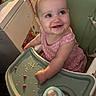 Bailey Baize is registered to the contest to win money with this photo: baby, child, high_chair, smiling, eating, food, bottle, infant, portrait, indoor, kitchen, seated, pink_clothing, brown_hair, blue_eyes, happy, toddler, mealtime, dining, family_home