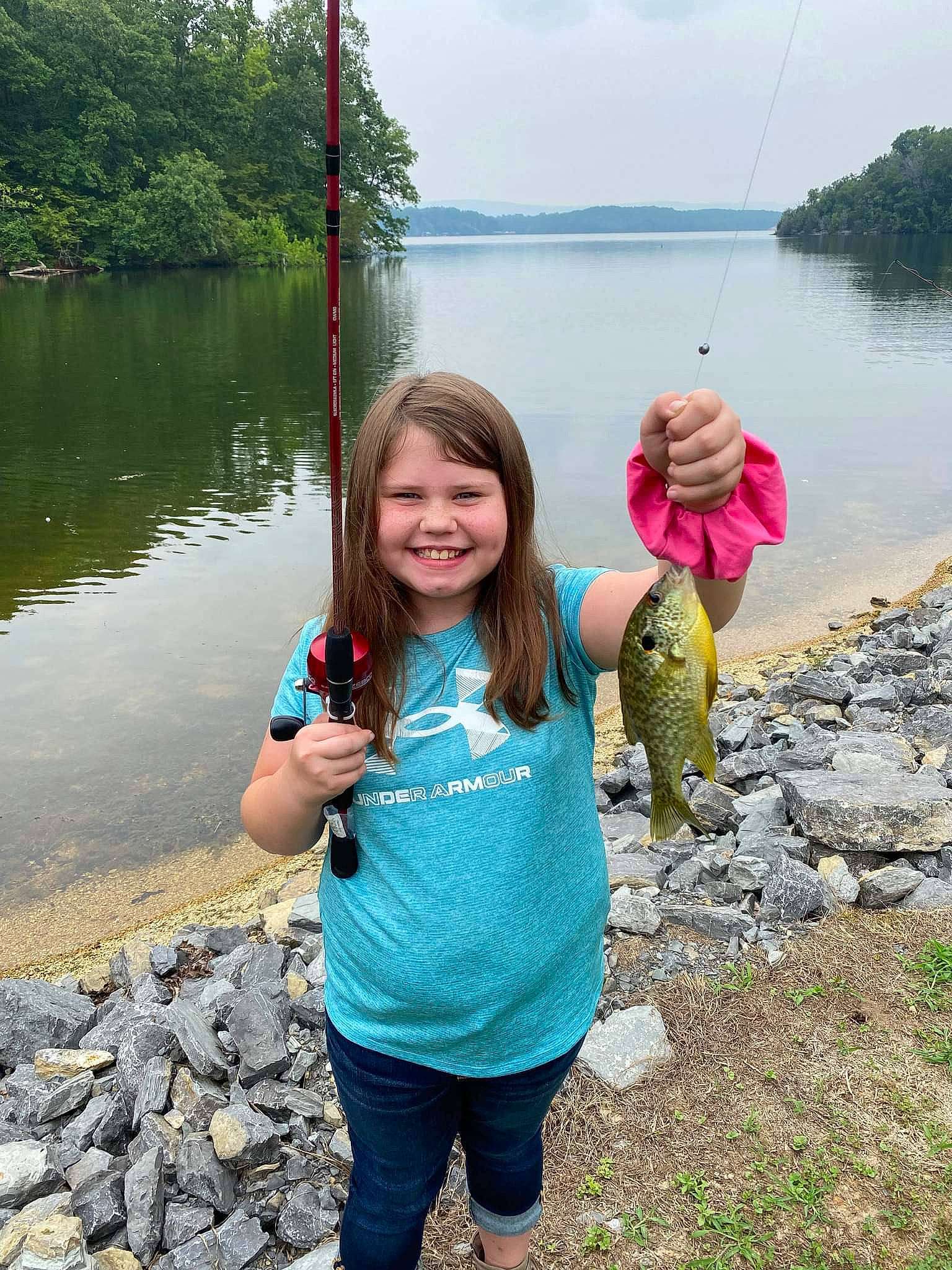 Rileigh joined the competition — help win amazing prizes! bank, body_of_water, botany, fun, grass, joy, lake, leisure, natural_environment, outdoor_recreation, people_in_nature, person, recreation, sky, smile, toddler, travel, tree, water, water_resources