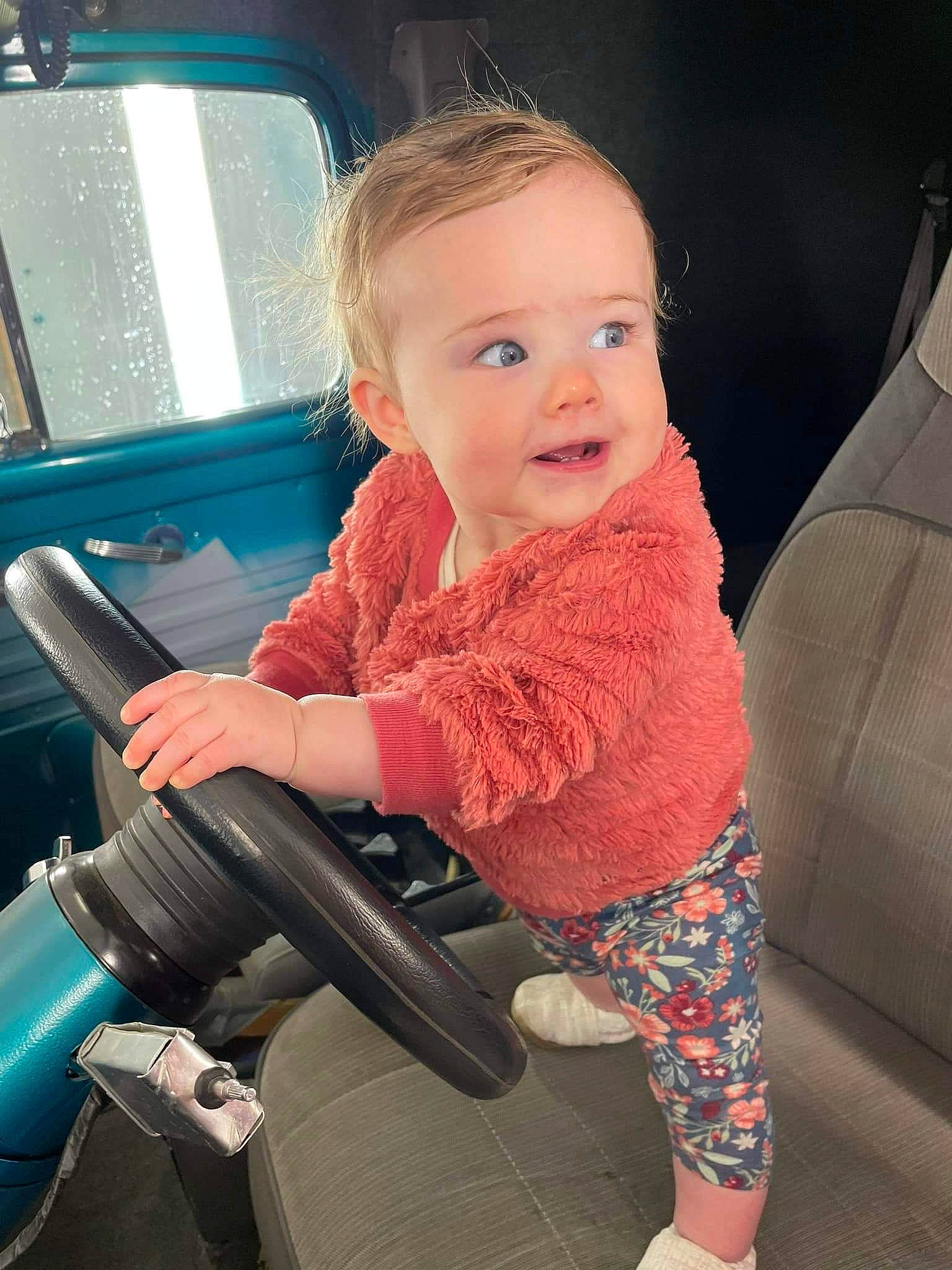 Esther joined the competition — help win amazing prizes! auto_part, automotive_design, baby_toddler_clothing, beauty, blond, car_seat, child, comfort, cool, electric_blue, finger, flash_photography, hand, leg, person, sitting, sleeve, sock, steering_wheel, toddler