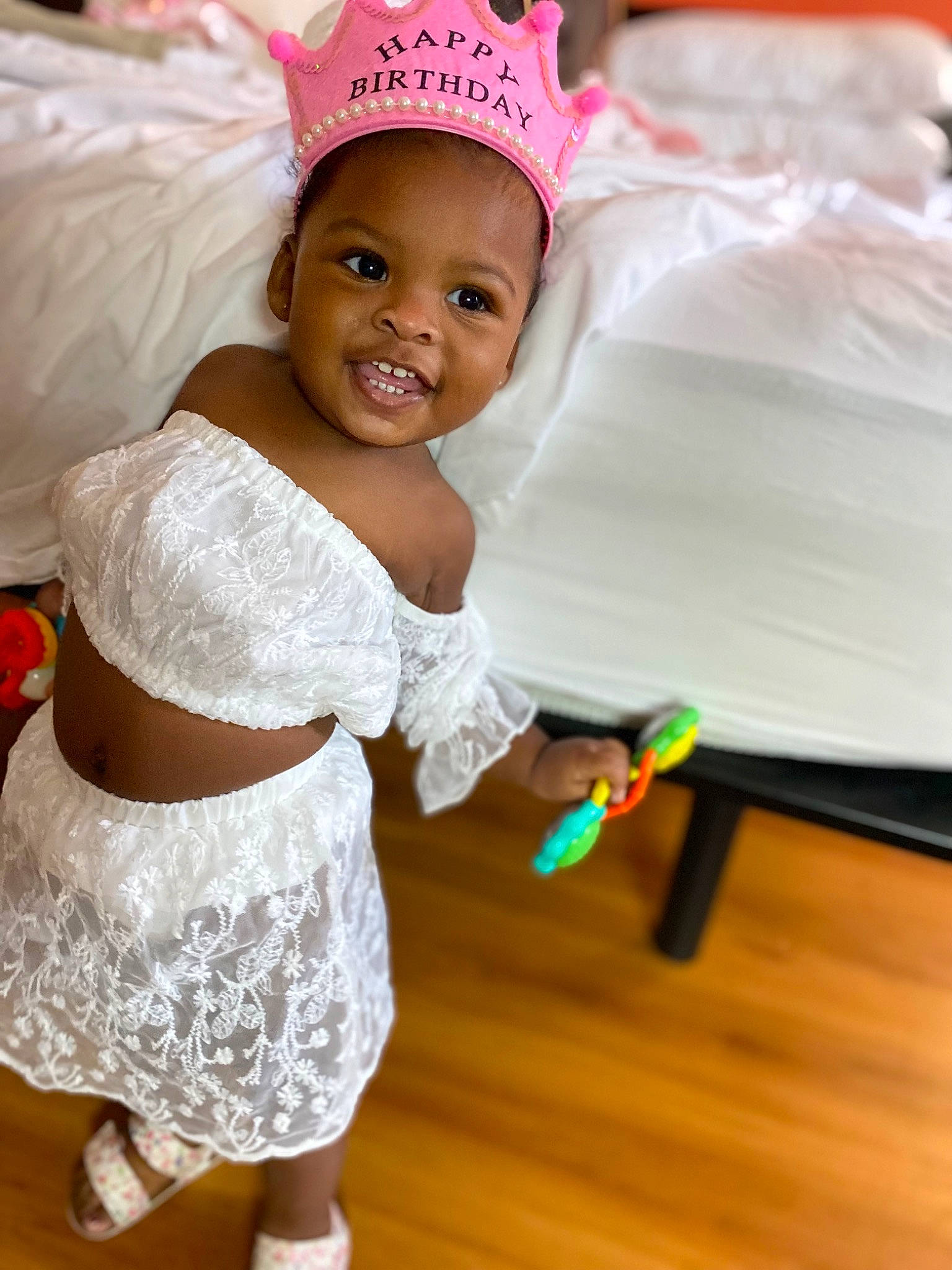 Tiara is registered to the contest to win money with this photo: baby, baby_toddler_clothing, birthday, cap, child, event, fashion_accessory, flooring, fun, hair_accessory, happy, headgear, headpiece, joy, magenta, party_supply, person, pink, room, skin