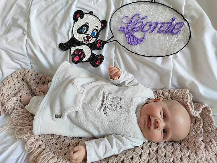 Léonie a rejoint le concours — aidez-le/la à gagner de superbes lots ! baby, baby_products, baby_sleeping, baby_toddler_clothing, bed, bedding, child, comfort, facial_expression, font, happy, linens, pattern, person, pink, product, sleeve, textile, toy, vertebrate