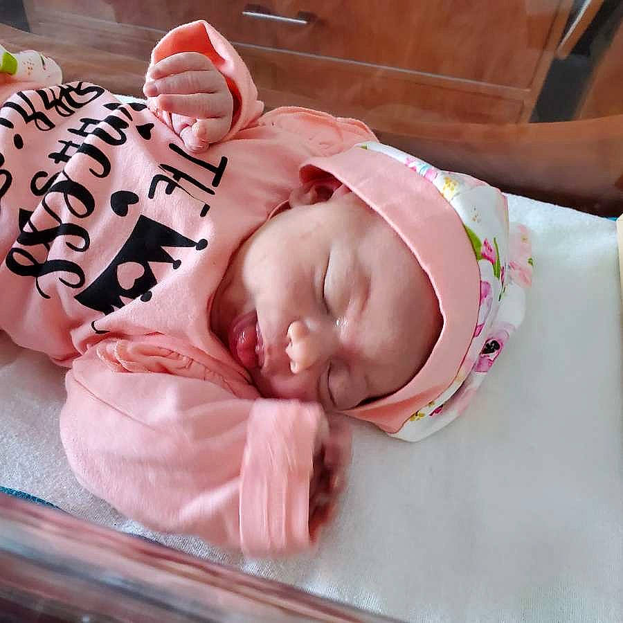 Estella is registered to the contest to win money with this photo: baby, baby_products, baby_sleeping, baby_toddler_clothing, bedtime, cheek, child, comfort, eyebrow, eyelash, face, fashion_accessory, happy, headgear, headwear, linens, lip, mouth, person, pink