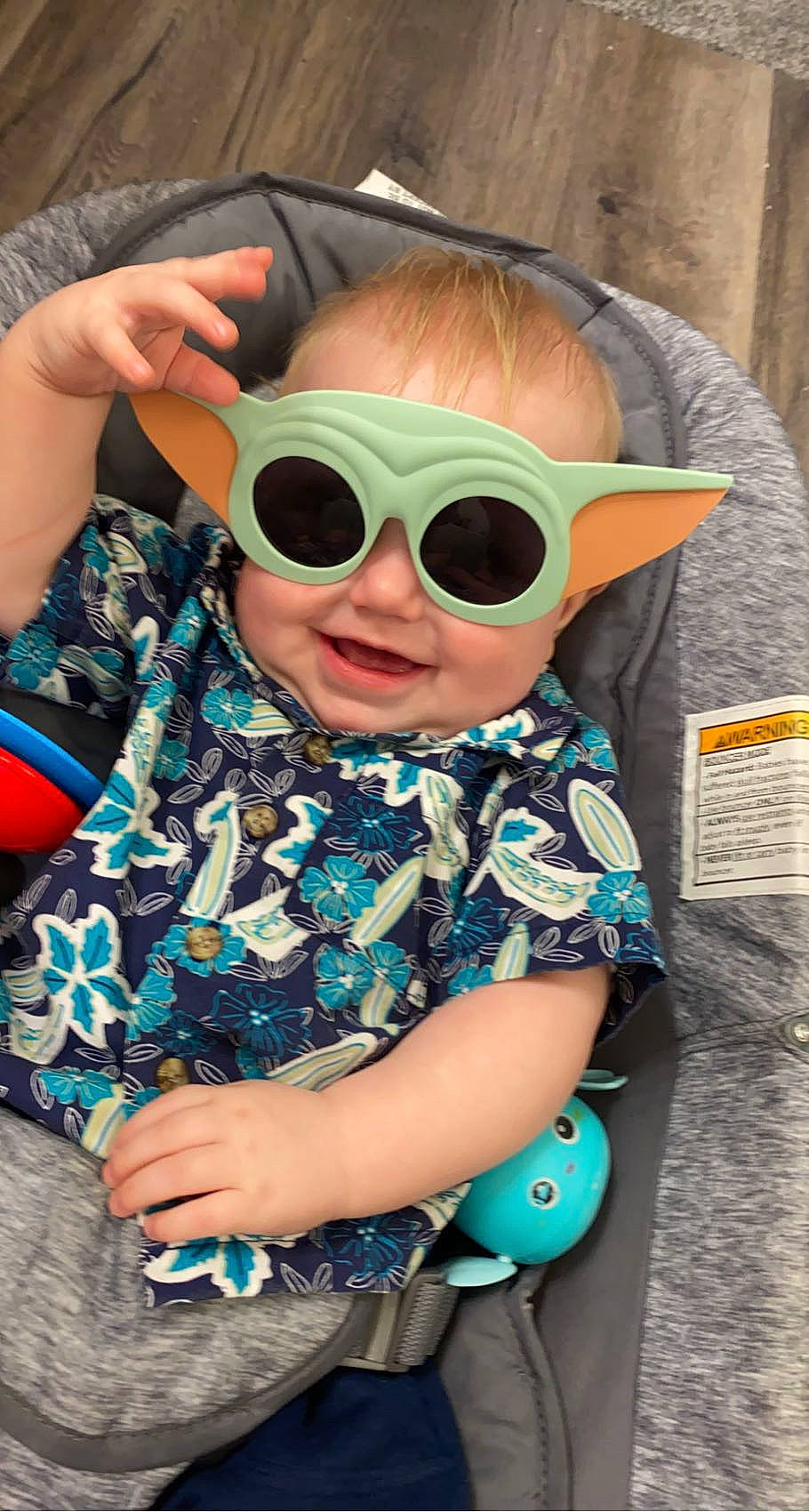 Leighton is registered to the contest to win money with this photo: baby_toddler_clothing, child, cool, electric_blue, eyewear, fun, glasses, goggles, hairstyle, hand, happy, joy, leisure, person, personal_protective_equipment, sitting, sleeve, smile, sunglasses, t_shirt
