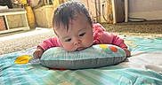 Carrusela joined the competition — help win amazing prizes! baby, infant, child, play_mat, pillow, pink_sweater, indoor, floor, carpet, toy, colorful, face, head, curious, resting, cozy, home, decor, sunlight, cute