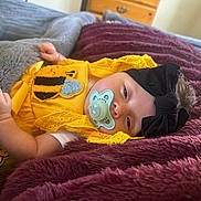 Carrusela joined the competition — help win amazing prizes! baby, infant, pacifier, headband, black_bow, yellow_outfit, bee_applique, blanket, maroon_blanket, gray_blanket, sleeping, cute, indoors, furniture, wooden_drawer, soft_texture, child, portrait, resting, cozy
