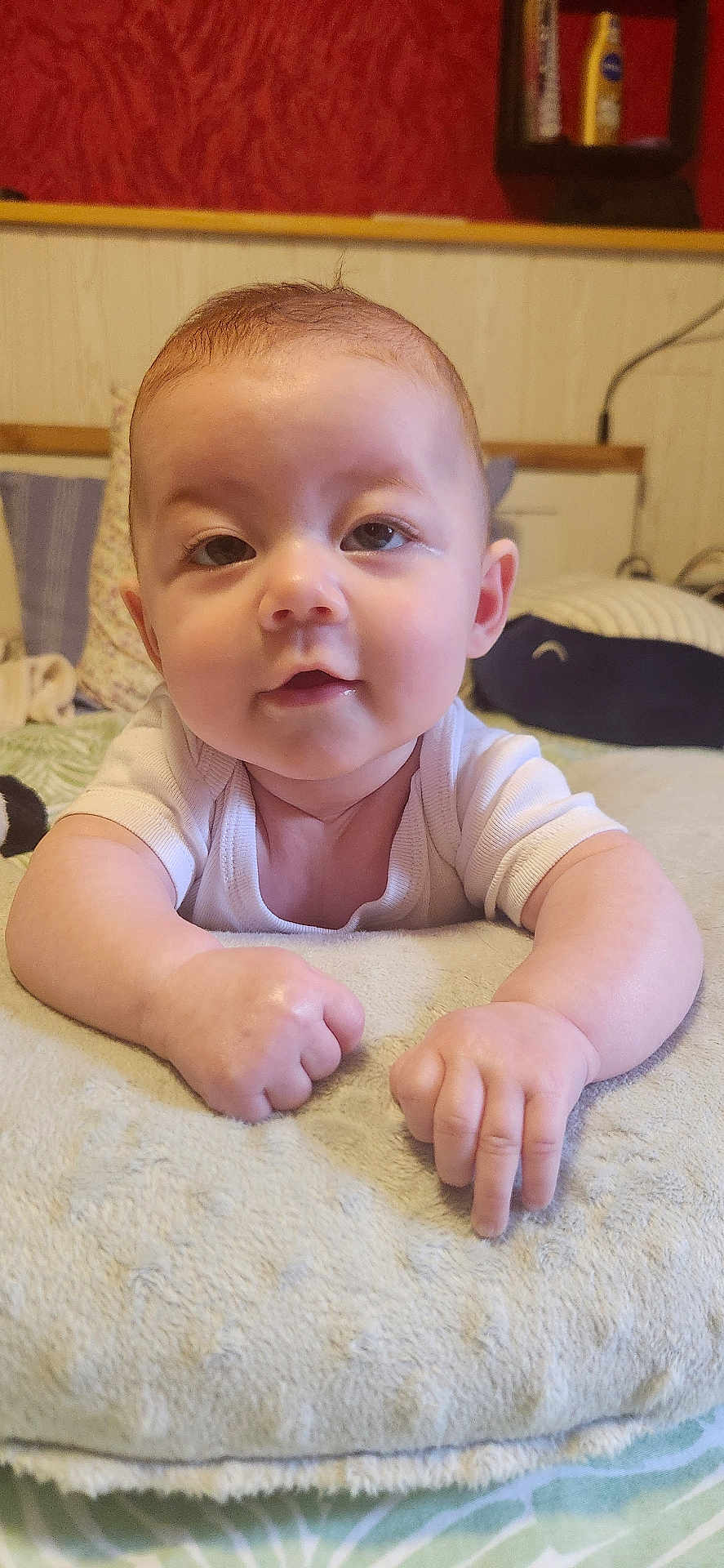 Stella a rejoint le concours — aidez-le/la à gagner de superbes lots ! baby, infant, cushion, pillow, bed, indoor, child, face, hands, skin, clothing, white_shirt, curious, lying_down, closeup, person, soft_texture, home, toddler, resting