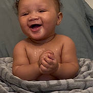 Manuel is registered to the contest to win money with this photo: baby, blanket, child, clapping, cozy, curly_hair, cute, expression, face, happy, home, indoor, infant, pillow, portrait, sitting, skin, smiling, toddler, young_child
