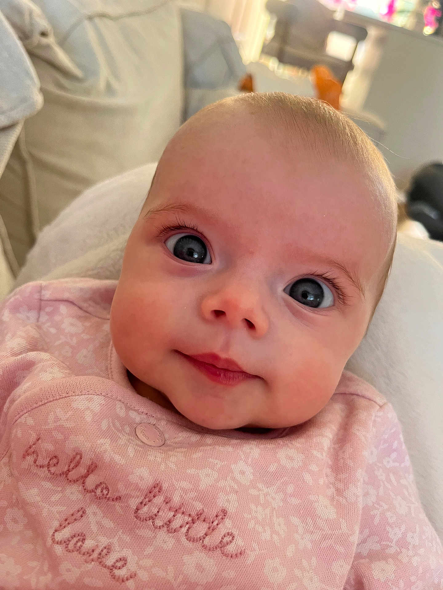 Bella joined the competition — help win amazing prizes! baby, infant, face, eyes, pink_clothing, smile, closeup, portrait, blanket, soft, indoor, cute, child, young, apparel, expression, skin, head, eyelashes, newborn