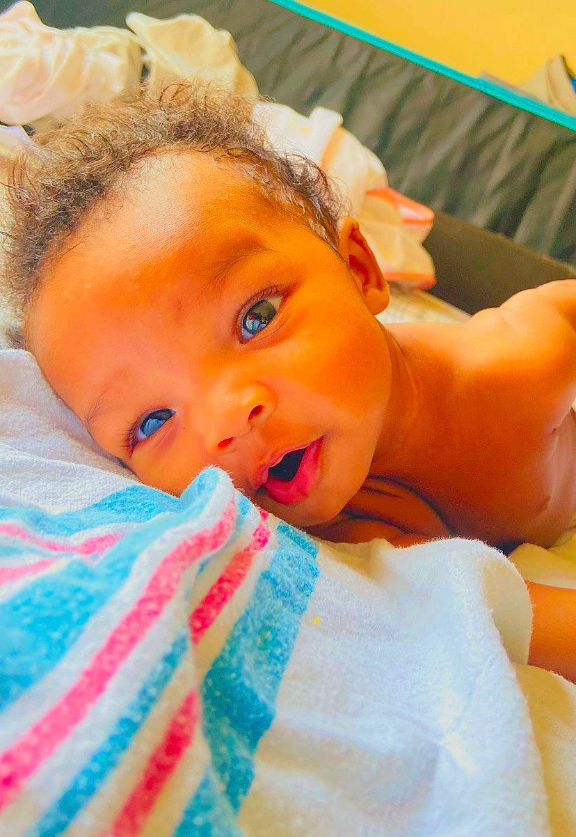 Reign is registered to the contest to win money with this photo: baby, baby_toddler_clothing, cheek, child, chin, comfort, dress, eye, eyebrow, eyelash, finger, fun, happy, iris, lip, mouth, nose, orange, person, skin