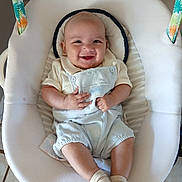Ares is registered to the contest to win money with this photo: baby, smiling, infant, baby_rocker, child, happy, sitting, clothing, socks, face, indoor, seat, cute, comfort, playful, soft, colorful, small_child, portrait, young