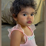 Ariella joined the competition — help win amazing prizes! toddler, child, girl, curly_hair, pink_dress, flower_pattern, portrait, indoors, cute, young_child, person, skin, face, eyes, hair, clothing, baby, fashion, standing, expression