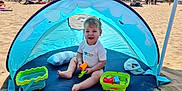 Pierre participe au concours pour gagner de l'argent avec cette photo : toddler, beach, tent, toy, sand, sunny, smile, child, play, bucket, hat, umbrella, outdoor, summer, vacation, happy, family, recreation, water, relaxation