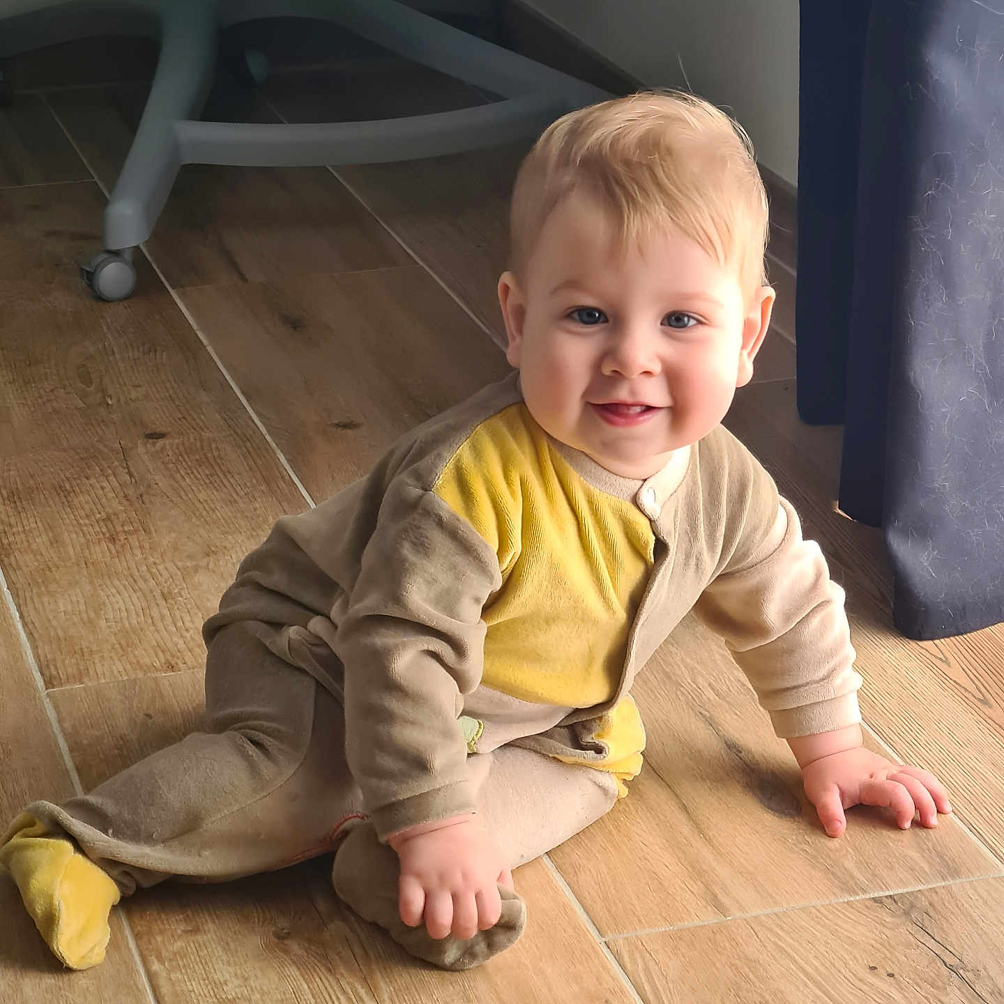 Pierre participe au concours pour gagner de l'argent avec cette photo : baby, blue_eyes, child, clothing, crawling, curtain, face, floor, footwear, furniture, hand, happy, head, indoor, light, onesie, person, shadow, smiling, wooden_floor