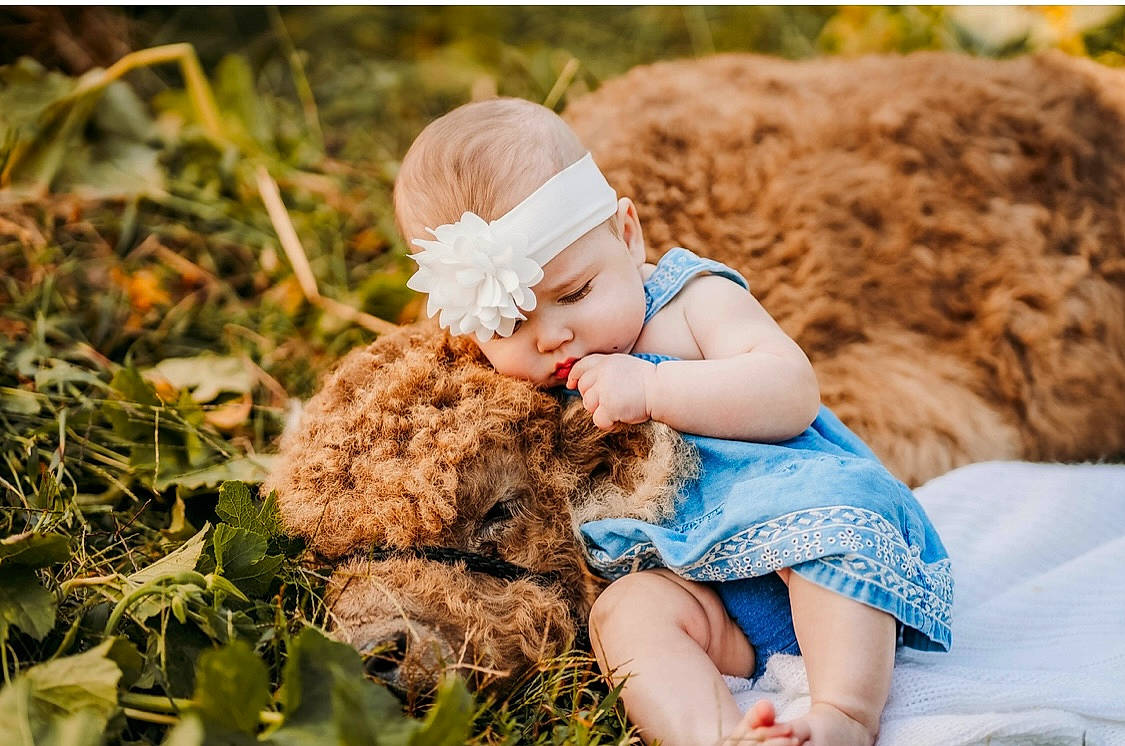 Khloe is registered to the contest to win money with this photo: baby, baby_toddler_clothing, blond, brown_hair, cap, child, clothing, fawn, fun, grass, hairstyle, happy, hat, headwear, people_in_nature, person, photograph, sitting, skin, toddler