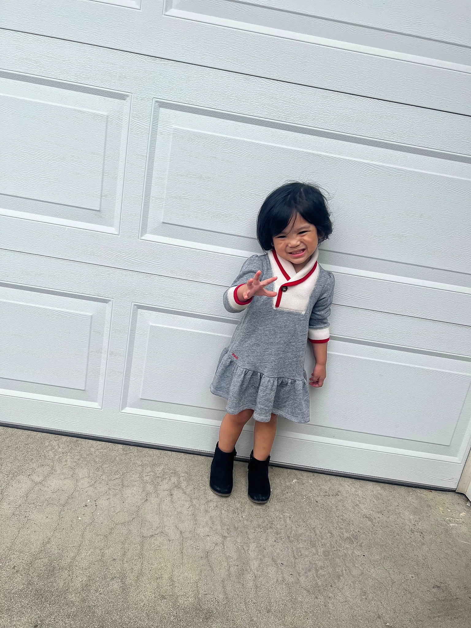 Sophie Magdalene is registered to the contest to win money with this photo: child, door, flooring, fun, happy, human_leg, joy, knee, magenta, pattern, person, room, sandal, sitting, sleeve, smile, sock, toddler, uniform, wall