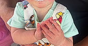 Jupiter is registered to the contest to win money with this photo: adult, baby, blue_eyes, cartoon_characters, child, closeup, clothing, cream, cute, expression, face, food, hands, indoor, lap, messy_face, overalls, person, sitting, skin