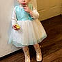 Leotie joined the competition — help win amazing prizes! apple, boots, child, clothing, curious, door, dress, expression, floor, food, holding, indoor, long_sleeve, person, sparkle, standing, toddler, white_wall, wooden_floor, young_child