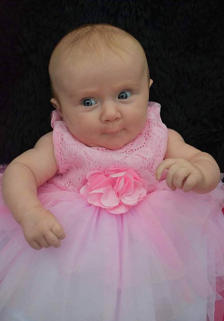 Astrid joined the competition — help win amazing prizes! arm, baby, baby_toddler_clothing, cheek, dress, eyelash, finger, gesture, happy, iris, lip, magenta, peach, person, pink, sitting, skin, sleeve, smile, thumb