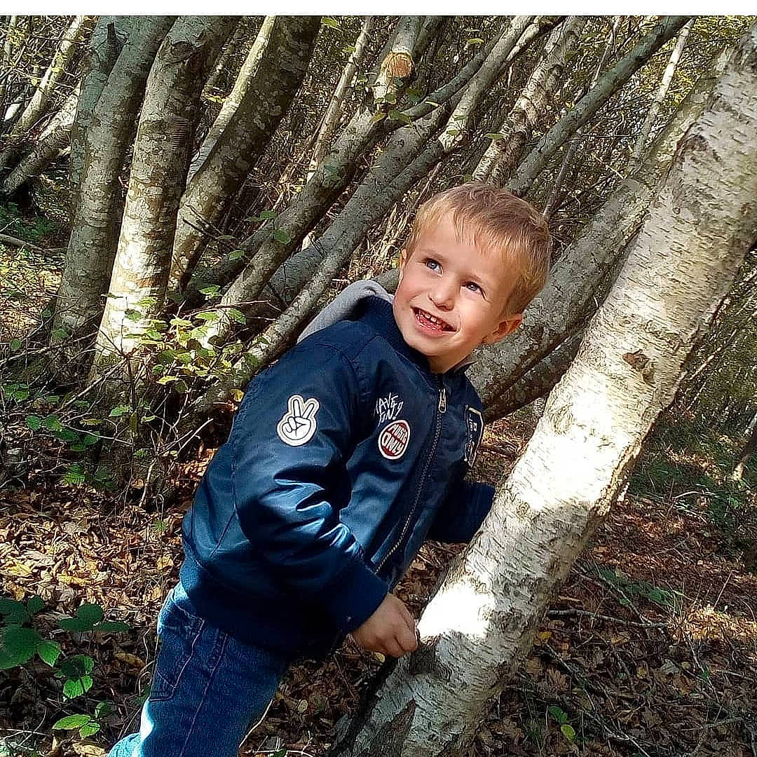 Ethan participe au concours pour gagner de l'argent avec cette photo : adaptation, branch, electric_blue, forest, grass, happy, jacket, joy, leaf, natural_environment, natural_landscape, nature, people_in_nature, person, plant, sleeve, smile, tree, trunk, wood