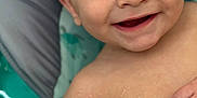 Reece is registered to the contest to win money with this photo: baby, bare_chest, child, close_up, cute, expression, eyes, face, hand, happy, indoors, infant, joyful, person, portrait, skin, smiling, soft_surface, water_droplets, young