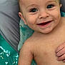 baby, bare_chest, child, close_up, cute, expression, eyes, face, hand, happy, indoors, infant, joyful, person, portrait, skin, smiling, soft_surface, water_droplets, young